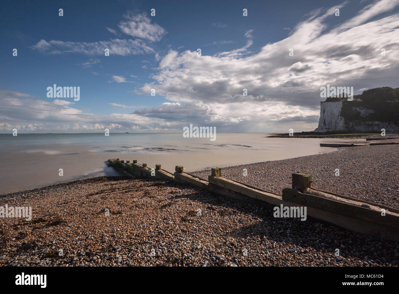 Long exposure at St Margaret's Bay on the English Channel, Dover, Kent, UK with the White Cliffs to the right and a wooden groyne in the foreground. Stock Photo