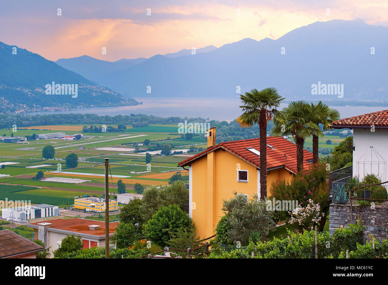 View of rural Southern Switzerland with houses, farms, vineyards, alps