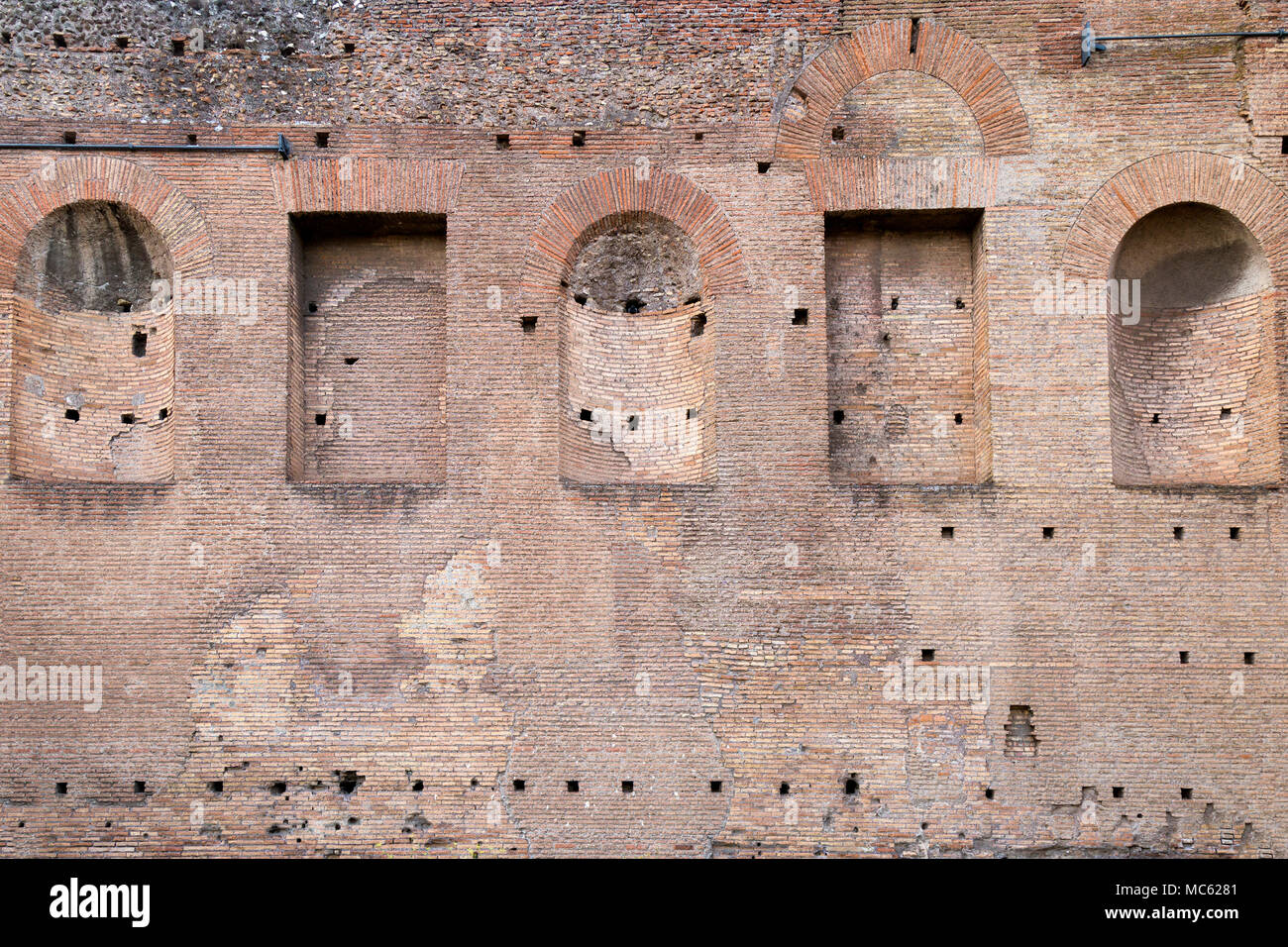 A section of brick wall with square and arched alcoves from the ancient palace ruins on Palatine Hill, Rome, Italy. Stock Photo
