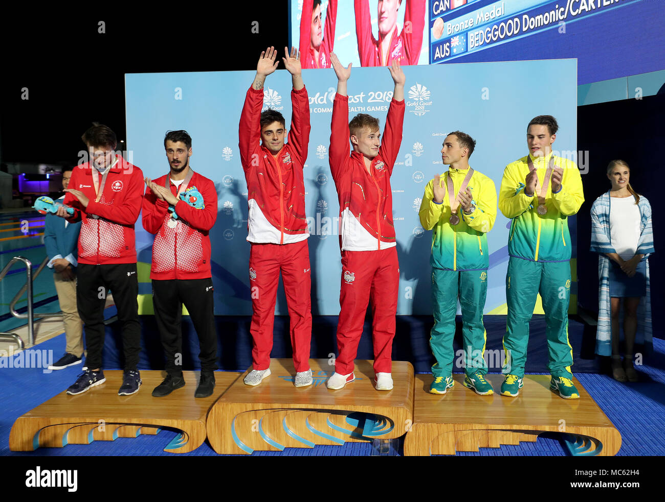 England's England's Jack Laugher (left centre) and Chris Mears celebrate winning gold on the podium, with silver medalists Canada's Philippe Gagne and Francois Imbeau-Dulac (left) and Australia's Matthew Carter and Domonic Bedggood at the Optus Aquatic Centre during day nine of the 2018 Commonwealth Games in the Gold Coast, Australia. Stock Photo