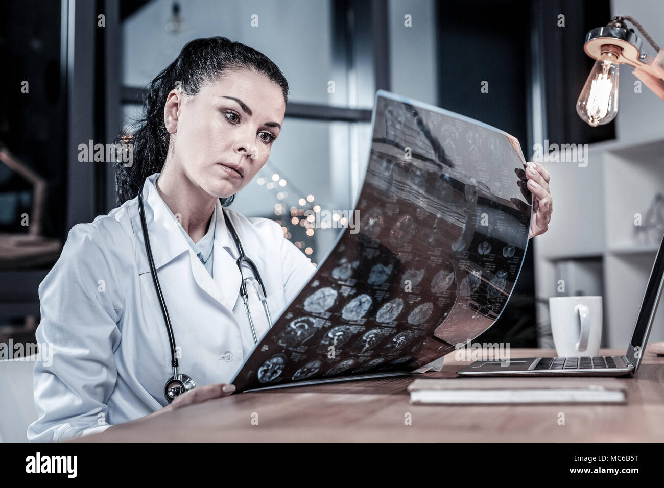 Serious busy medic holding and overlooking x-ray scan Stock Photo - Alamy