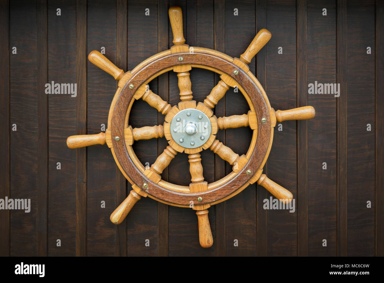 Wooden metal old wheel steering on wood background. Stock Photo