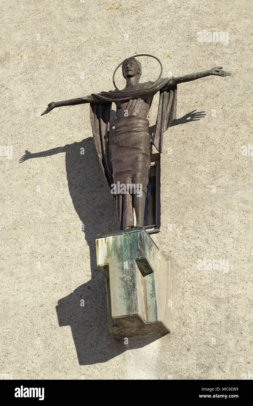 Copper Jesus sculpture on Bodø's chathedral throwing shadows on the