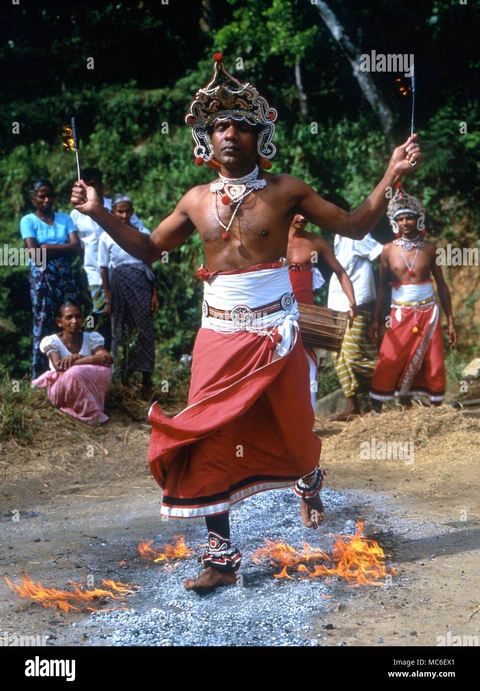 FIRE-WALKERS Fire-walker walking on burning coals to the ritual drumming, in a rural village to the north of Kandy, Sri Lanka Stock Photo