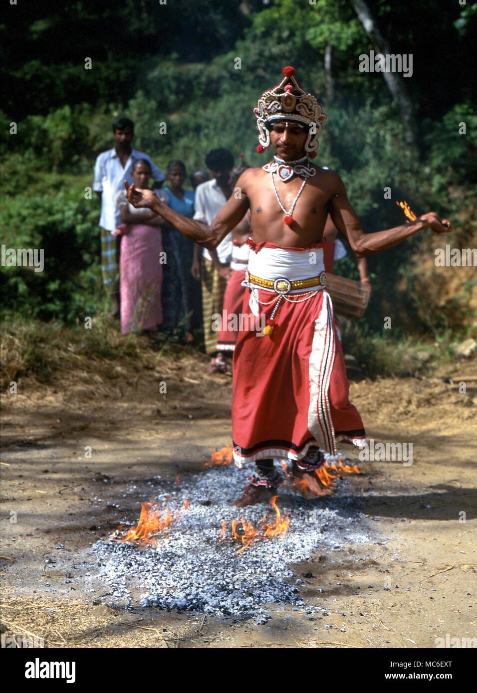 FIRE-WALKERS Fire-walker walking on burning coals to the ritual drumming, in a rural village to the north of Kandy, Sri Lanka Stock Photo
