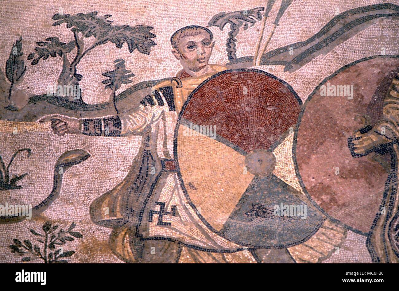 SWASTIKA Swastika symbol on tunic of man with large shield. Roman mosaics of the 3rd century AD, in the vast Roman Villa at Casale, near Piazza Armerina. This is one of the finest relics of the Roman Age Stock Photo