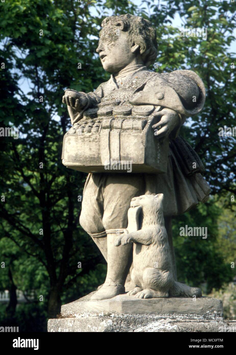 Statue of pedlar-boy and his cat, the cat holding his 'wares list' in its mouth. In the formal gardens of the Residency, Wurzburg, Germany. Stock Photo