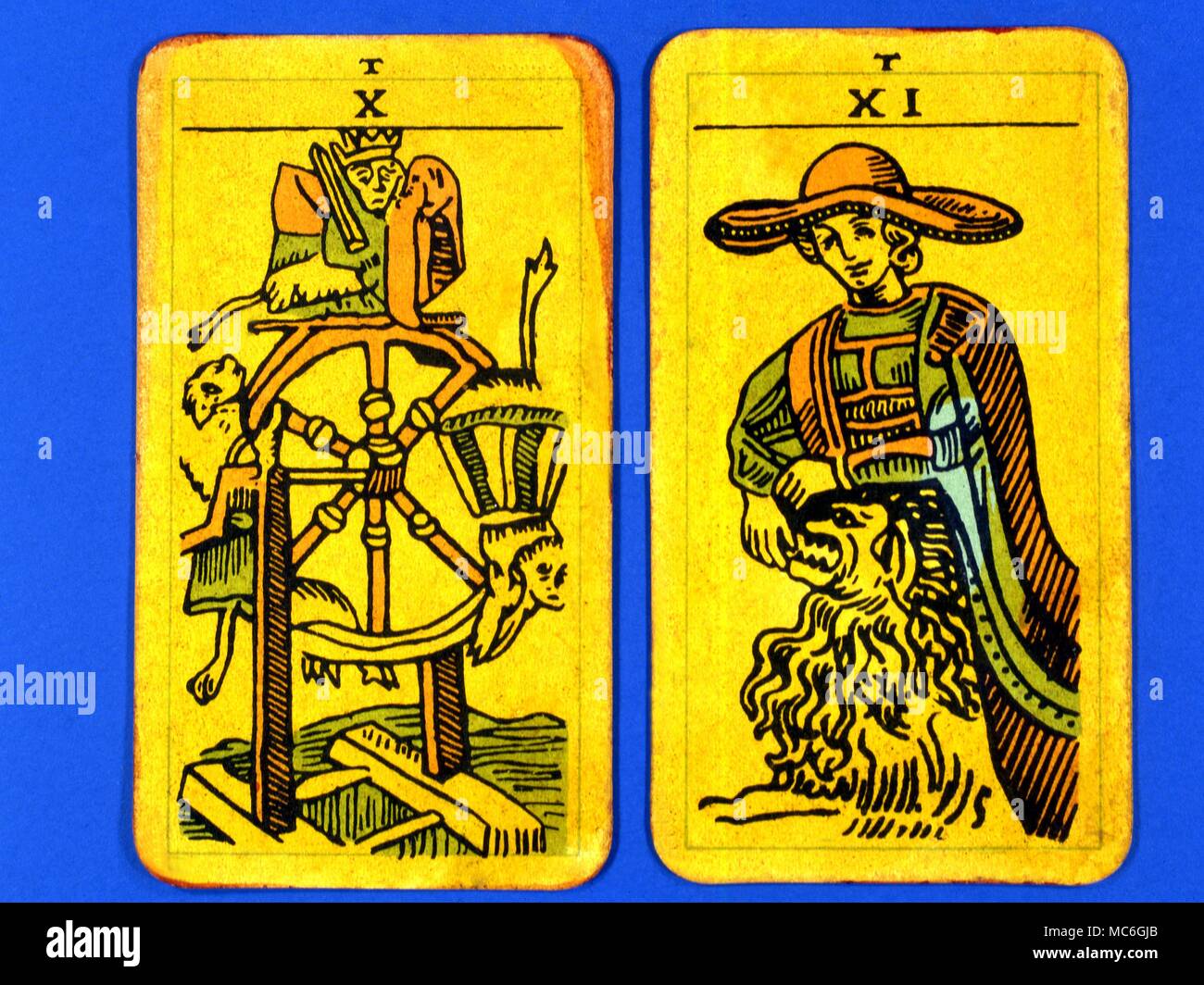 Tarot Cards-Majo Arcana- The Parisian Tarot. Card 10. The Wheel of Fortune, and Card 11. The Strength. Two cards from a Major Arcana picture Tarot,adapted by a Wiccan group. Probably designed in an archaizing style in loose imitation of the Rosicrucian deck designed by Pamela Coleman Smith, alongside A.E.Waite, and various earlier decks, such as that published by Encausse (Papus) in The Tarot of the Bohemians at the end of the 19th century, post 1905, but earlier than 1912. The name Parisian Tarot was given by the owner of the deck - it might however be called the Tau Tarot, from the intrigui Stock Photo