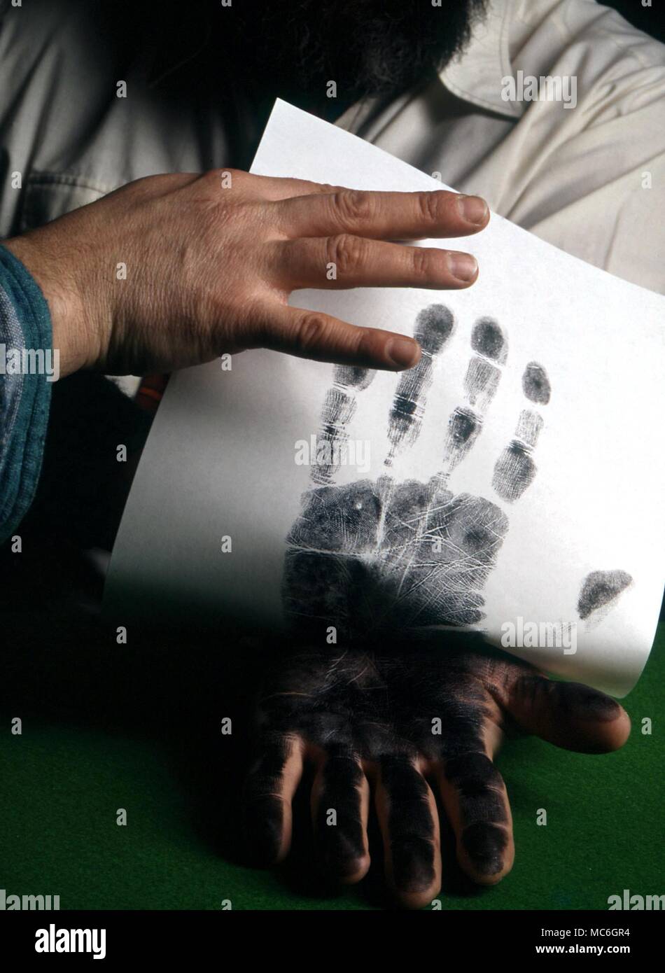 PALMISTRY - Making a palm print. Palmist making a palm print of client for ease of inspection of the lines Stock Photo