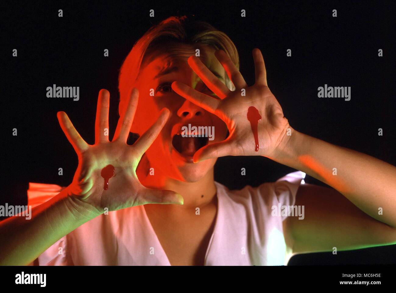 Dramatic portrayal of stigmata - blood on the hands of a girl Stock Photo