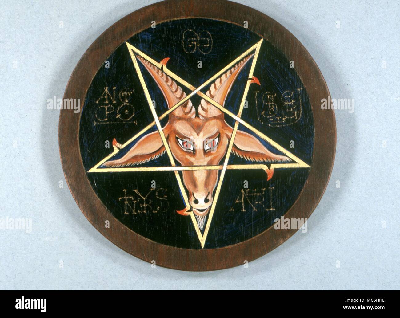 Magic symbols. Pentacle with a goat's head surrounded by alphabet of desire sigils.Ritual disk. Stock Photo