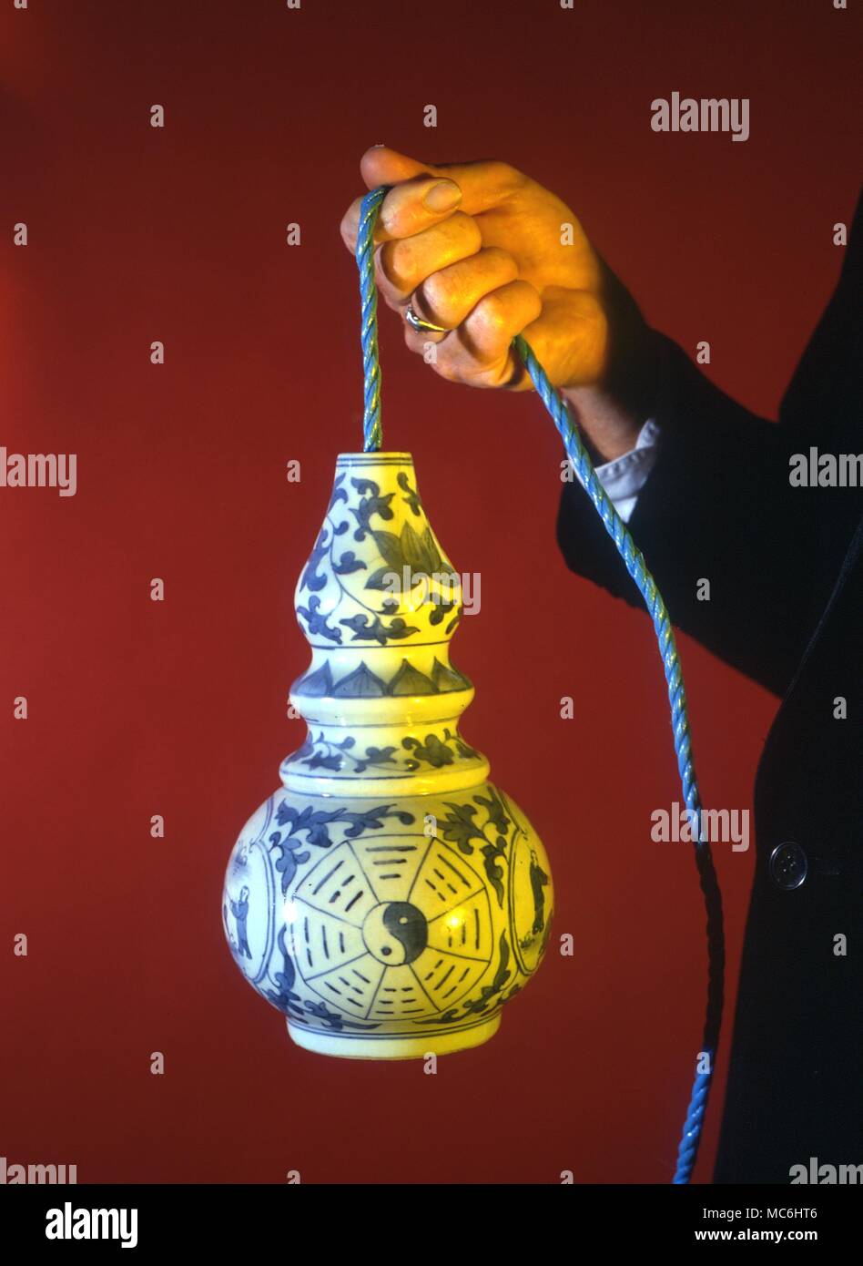 Stage Magic - Magic Rope. Magician puts the end of a rope into a bowl. The rope will not come out and even hold the bowl, until he commands it to let go. Stock Photo