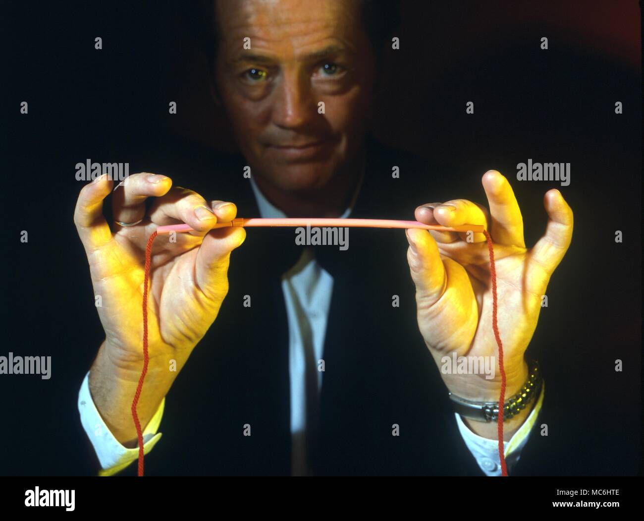 Stage Magic Cutting through a Straw. Magician runs string through