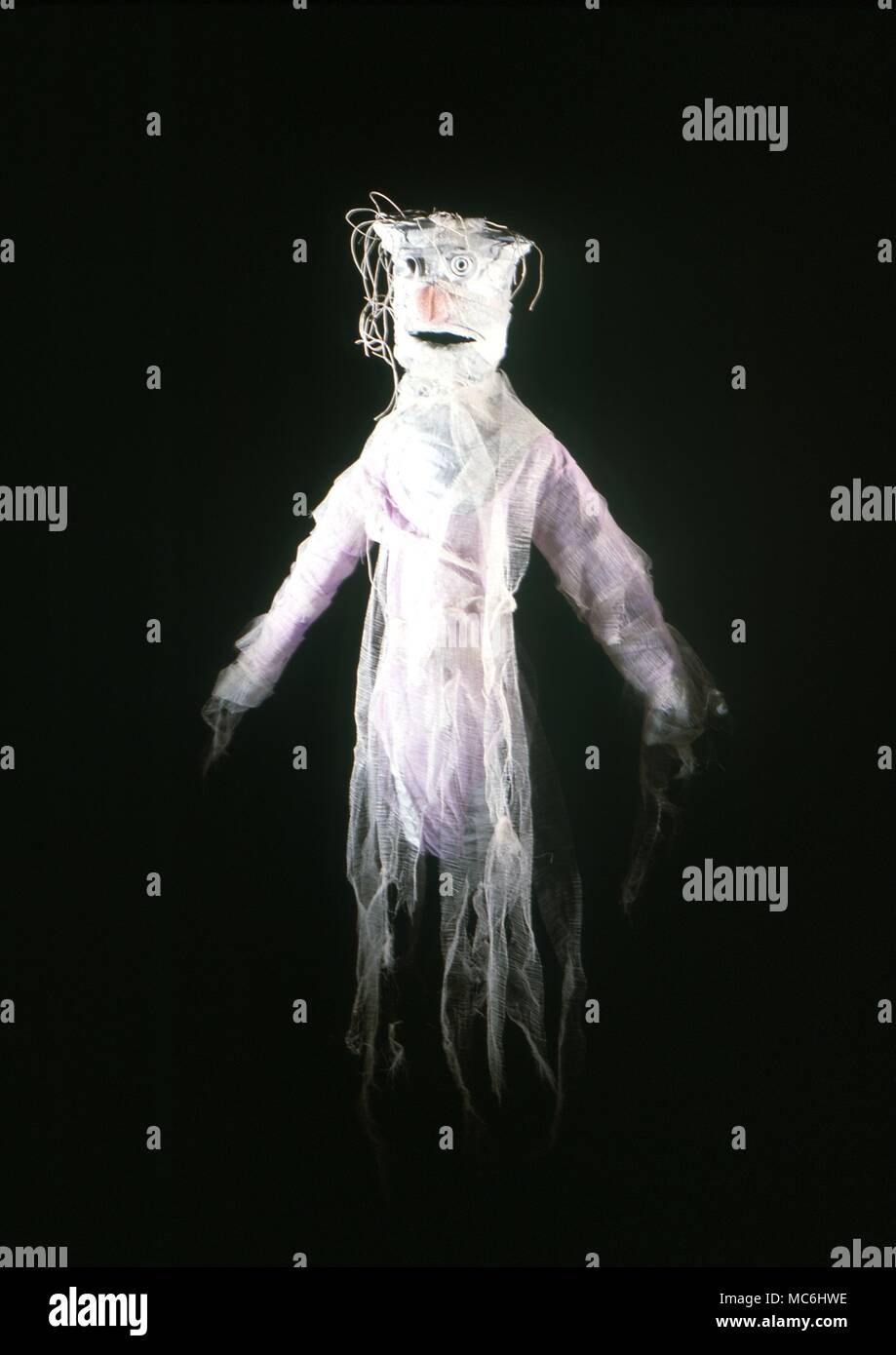 Stage Magic - Ghost from a hat. The magician shows the audience an empty hat and then proceeds to take from it a human-sized ghost! The ghost is made of muslin and its form is derived from thin coiled wire springs; it therefore fits easily into a hat. Stock Photo