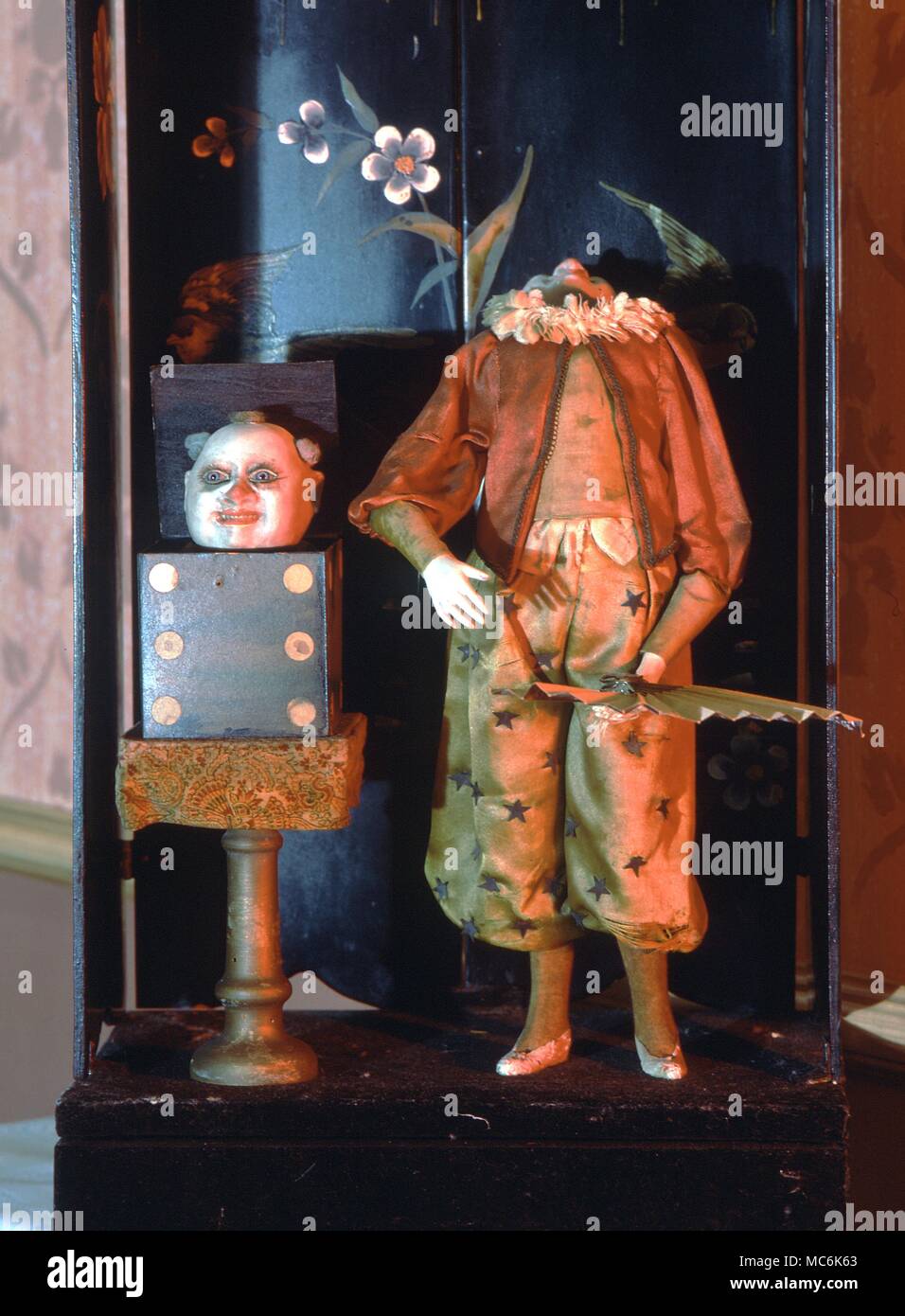 Automata Magical automaton by Jean-Marie Phalibois c. 1875. The magician raises his fan to his face and lowers it to reveal that his head has disappeared. It emerges from the dice box to the magician's left. Museum of Automata, York Stock Photo
