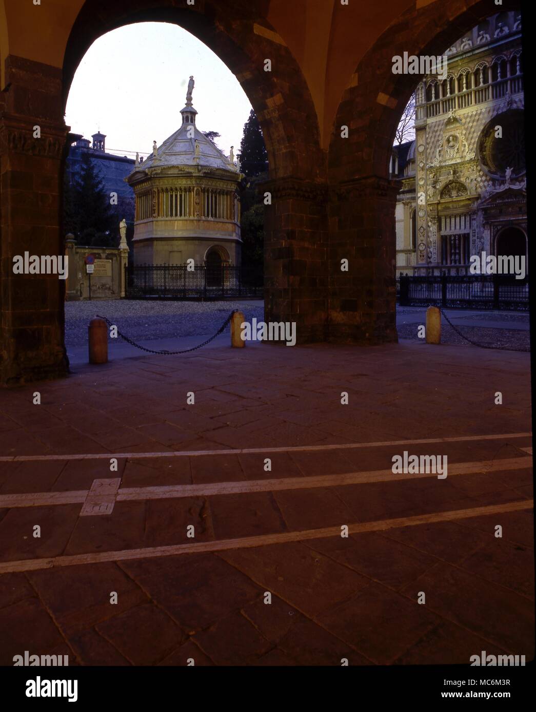 Light Mysteries. The horlogium, which receives the daily sun-marking of zodiacal position, under the old town hall of the Alta Citta, Bergamo, Italy. Through the arches are the baptistry and the cathedral. Stock Photo