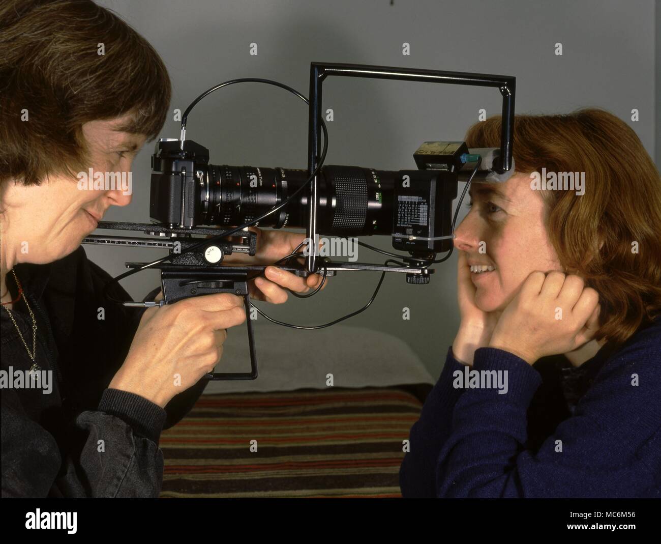 Iridology. The iridologist and herbalist, Barbara Penny, taking photographs of the eye of a pupil as an aid to iridological diagnosis. Stock Photo