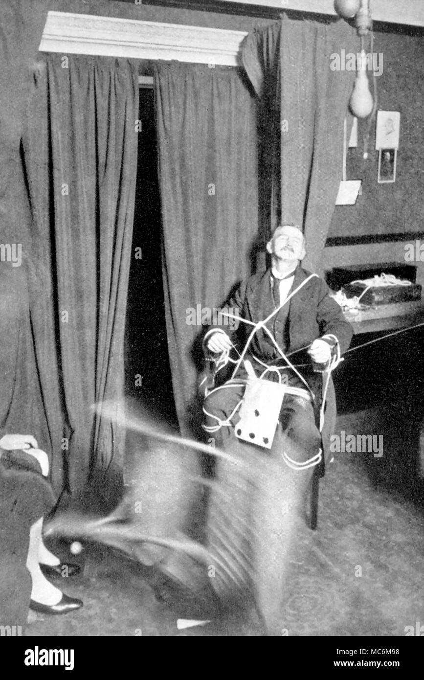 Seance - Table Levitation. Table levitating so quickly as to be a blur in the photograph. Note that medium in a catatonic trance. The medium is J. Lewis, working under test conditions in the College of Psychic Science, May 1928. Stock Photo