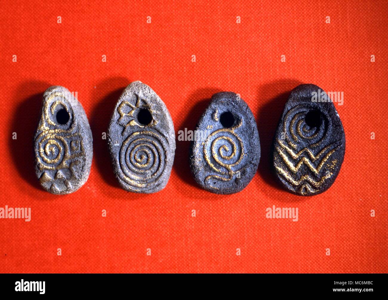 DIVINATION - CELTIC SPIRAL STONES. Sacred spiral stones used, among other things, for divination. The designs are bassed on ancient celtic carvings. left to right: determination and Earth; fertility; Water and kindness; Fire and confidence Stock Photo