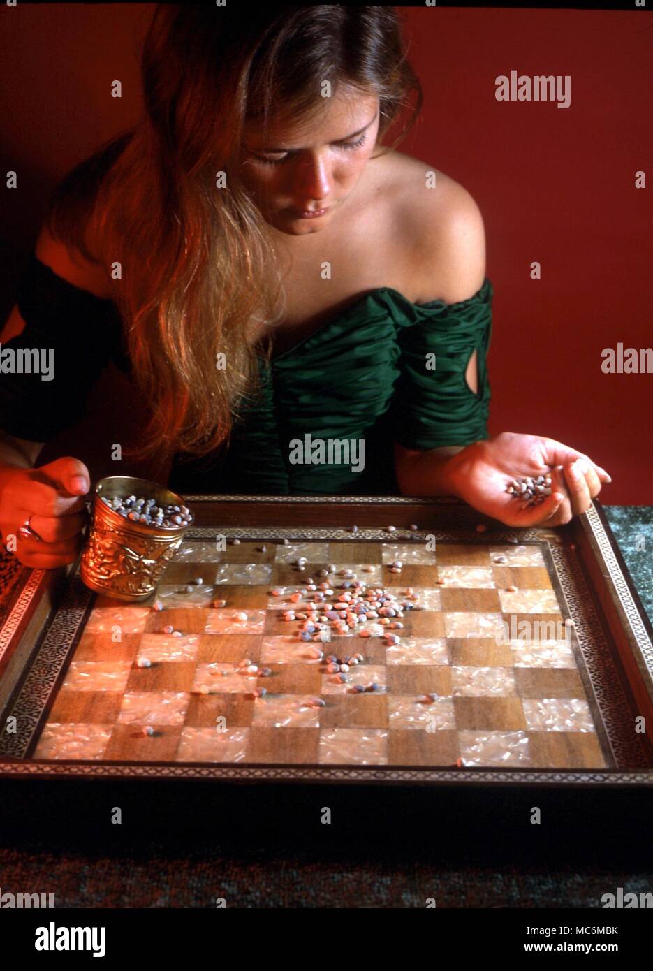 DIVINATION - GEOMANCY. Divination by means of the earth or pebbles. In this technique, the diviner throws small pebbles on to a chess bord. The pebbles in specific squares are counted, and the odd and even numbers used to construct a geomantic figure Stock Photo