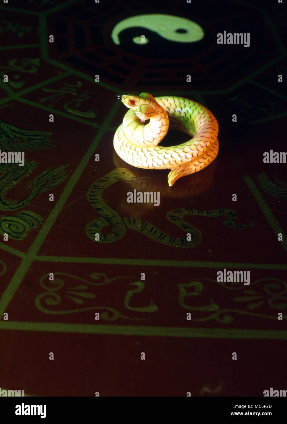 The Chinese symbolical animal Snake, the equivalent of Virgo. Animal photographed against Chinese silk. Small ivory carving from China. 2004 Charles Walker / Stock Photo