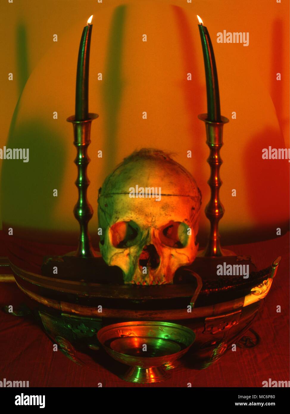 Ritual altar [in distorted mode] with skull, candles, grimoire, ritual dishes, etc. Stock Photo