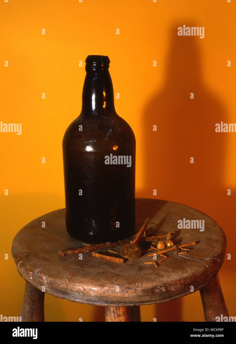 An eighteenth century witch bottle, which contained rusty bent nails, small metal objects [well rusted] and one impaling nail. WITCHCRAFT - WITCHBOTTLE. 18th century witch bottle, in which were found bent nails, and other magically charged objects. Such bottles were usually placed behind chimneys, to ward off the danger of witches Stock Photo