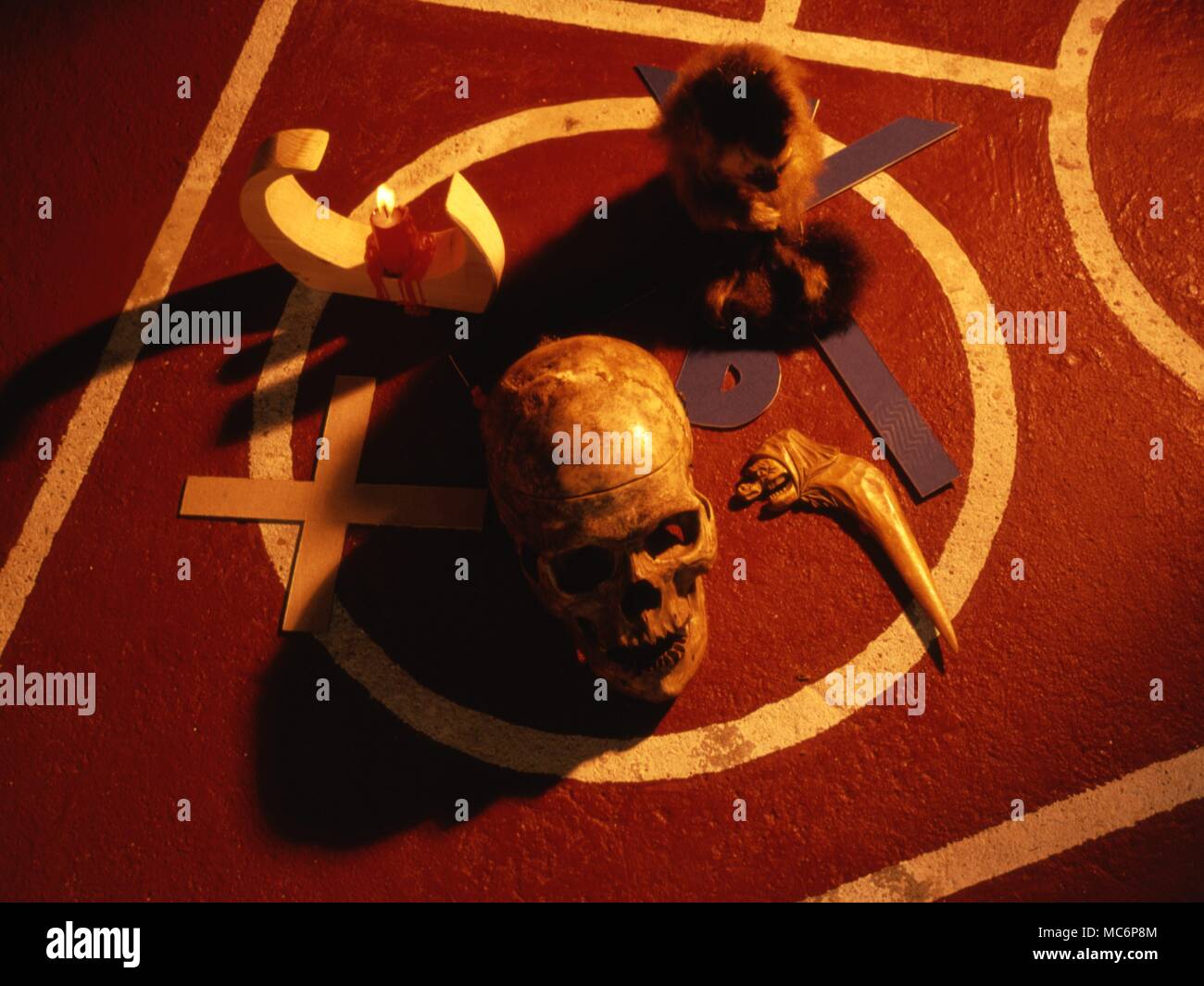 Ritual objects on a specially marked floor, in preparation for the ritual of the Rite of Thoth. The system was designed by Eliphas Levi. The objects include various symbols proposed by Levi, a candle, skull and stuffed marmoset, etc. Stock Photo