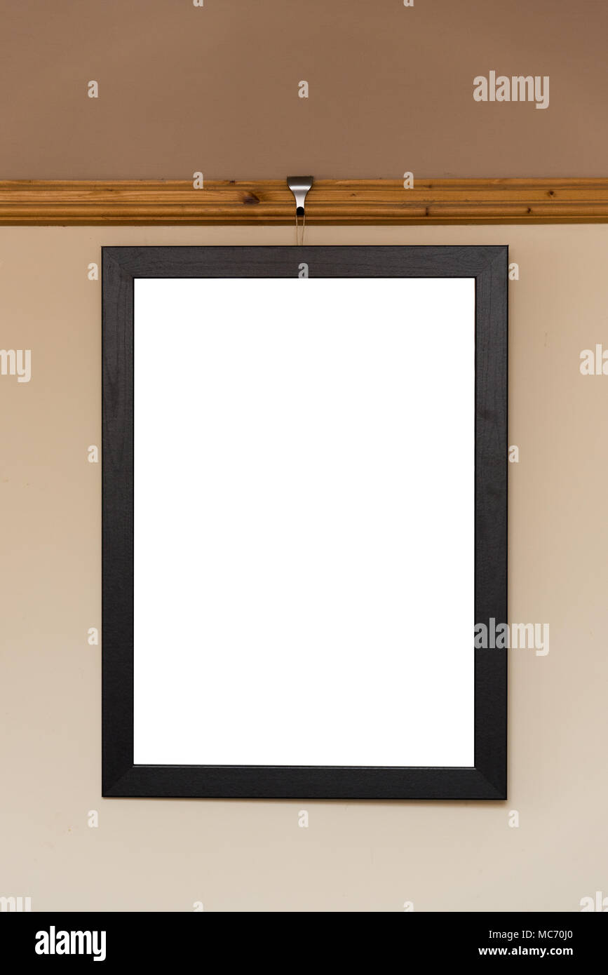 Blank photo frame hanging on a dado rail in a living room Stock Photo