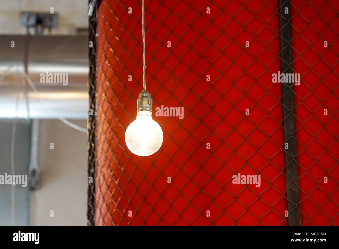 Lighting decor . lighted bulb with red wall as a background Stock Photo