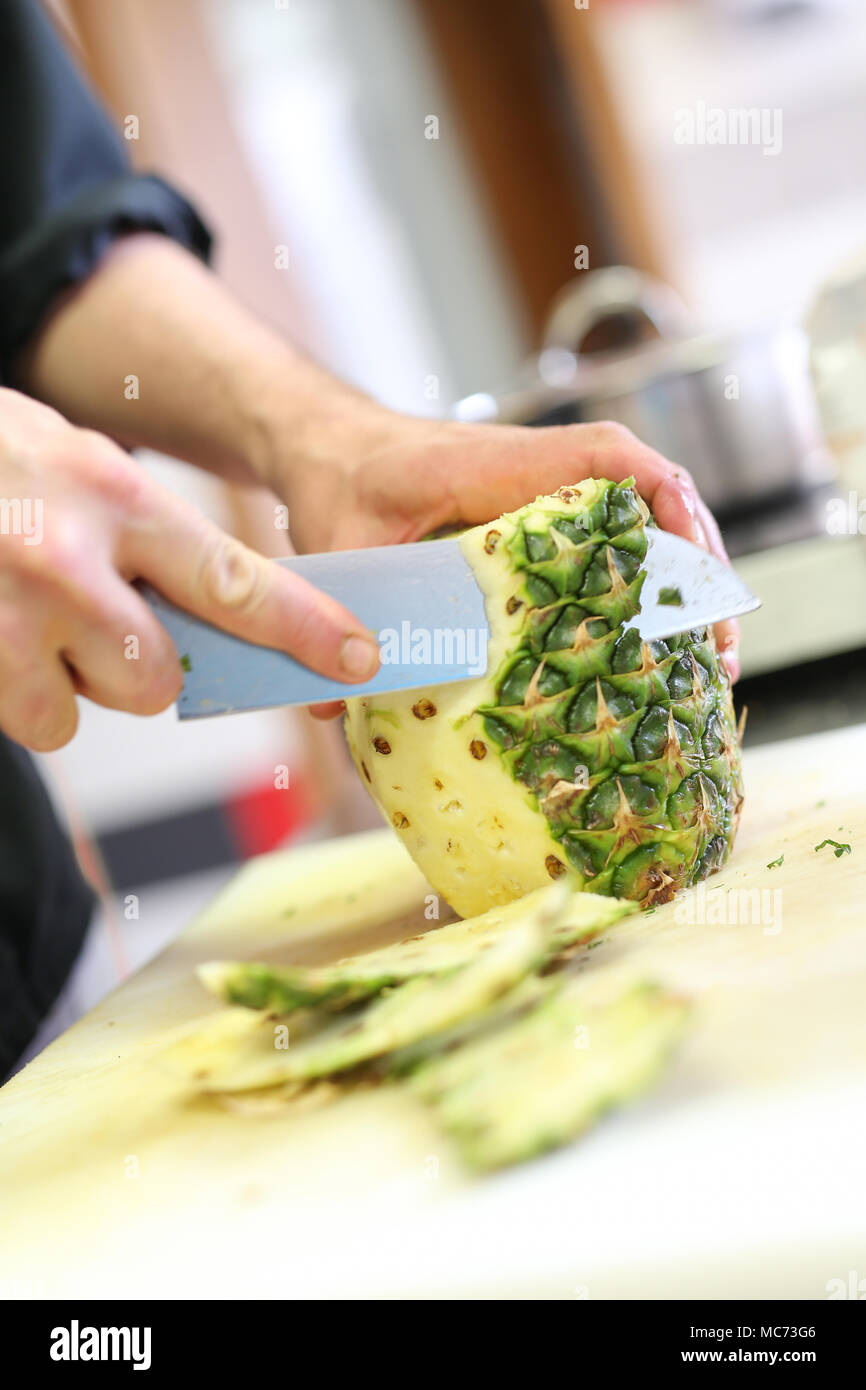 Cook cutting a pineapple Stock Photo