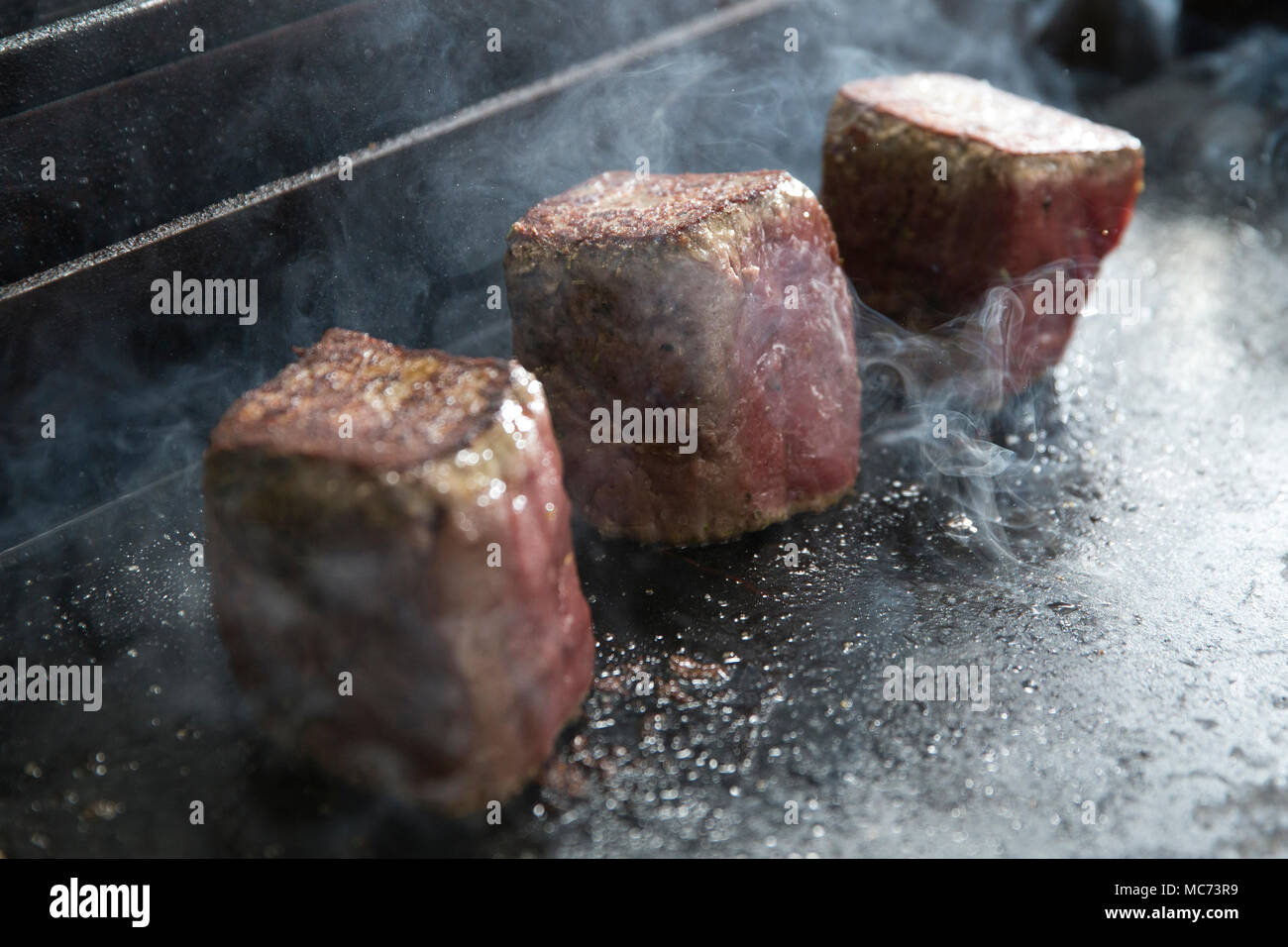 three pieces of beef fillet cooking on a hotplate Stock Photo Alamy