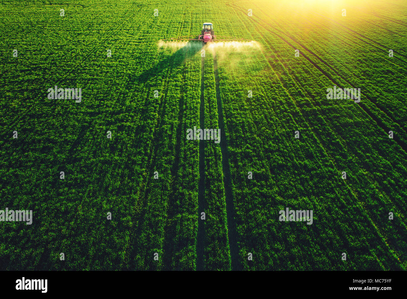 Aerial view of farming tractor plowing and spraying on field Stock ...