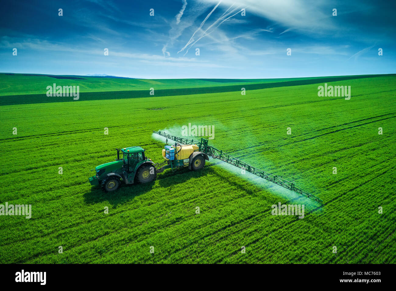 Aerial view of farming tractor plowing and spraying on field Stock ...