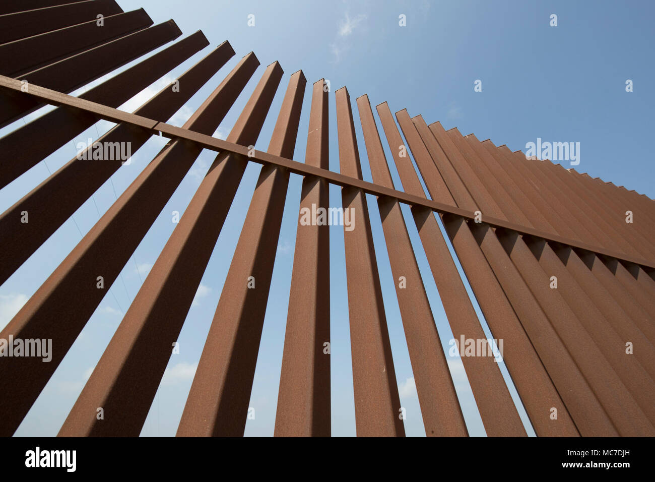 A section of the security fence between the United States and Mexico sits atop a levee of the Rio Grande River on the Texas side of the international border in Hidalgo County. Stock Photo