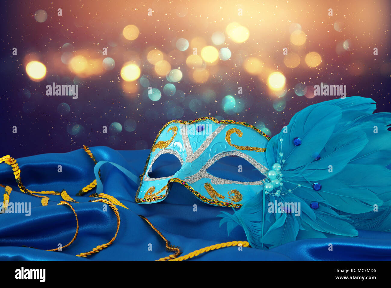 Image of elegant blue and gold venetian mask over blue silk fabric ...