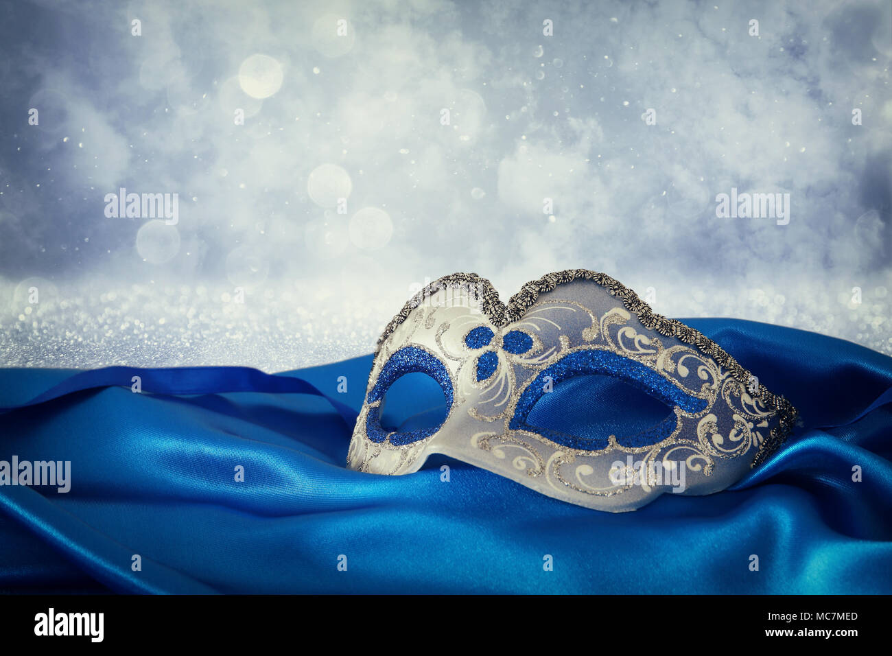Image of elegant blue and gold venetian mask over blue silk fabric ...