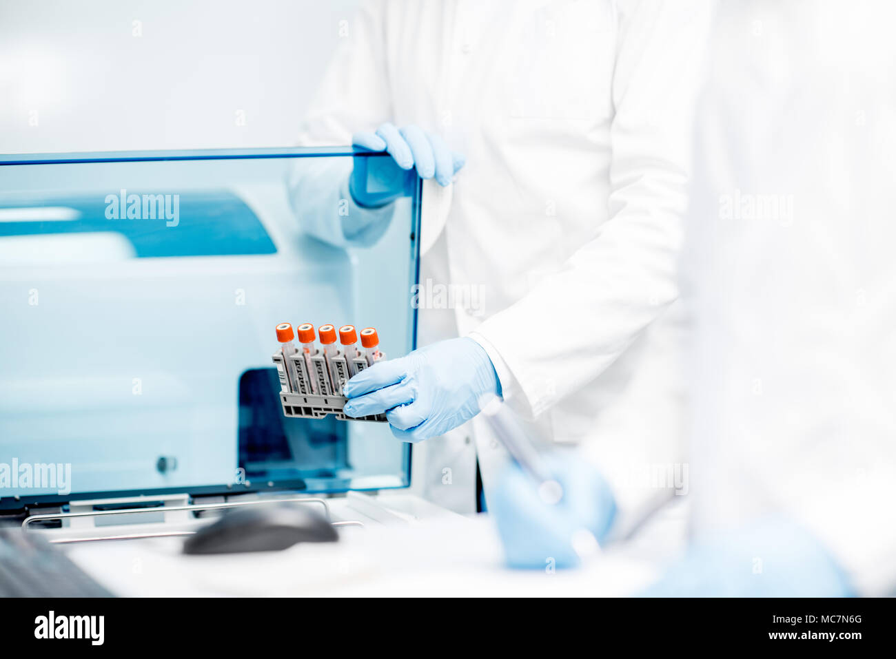 Laboratory assistant filling test tubes into the analyzer machine Stock Photo