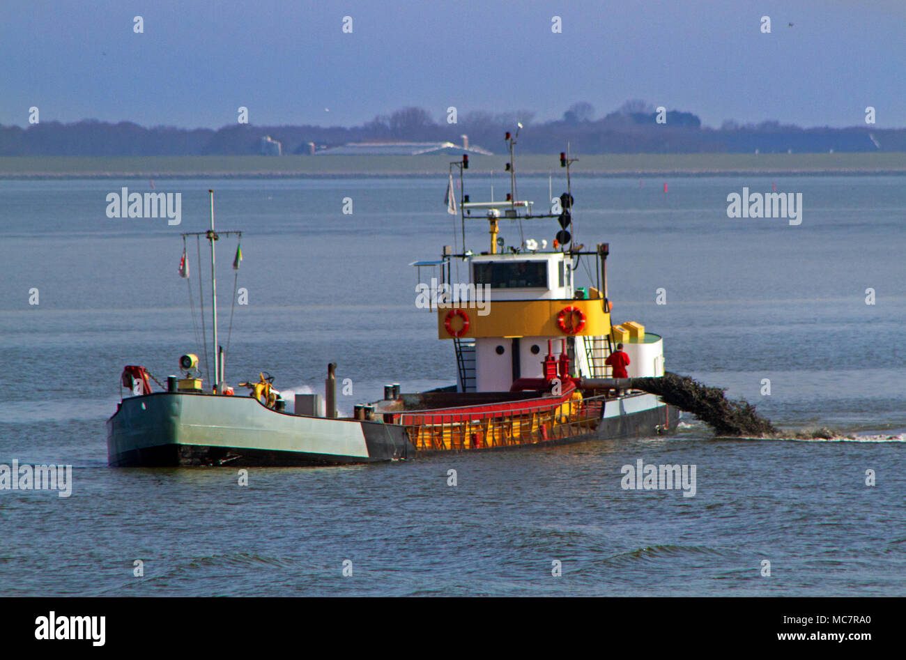 Suction dredger ship working in a fairway near the Dutch island Schiermonnikoog Stock Photo