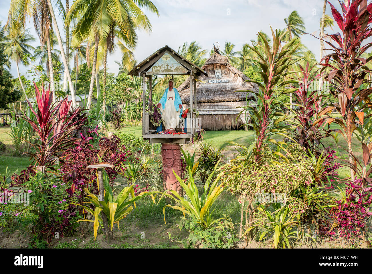 A Christian niche with a Virgin Mary statue in front of a Haus Tambaran, Korogo Village, Middle Sepik, Papua New Guinea Stock Photo