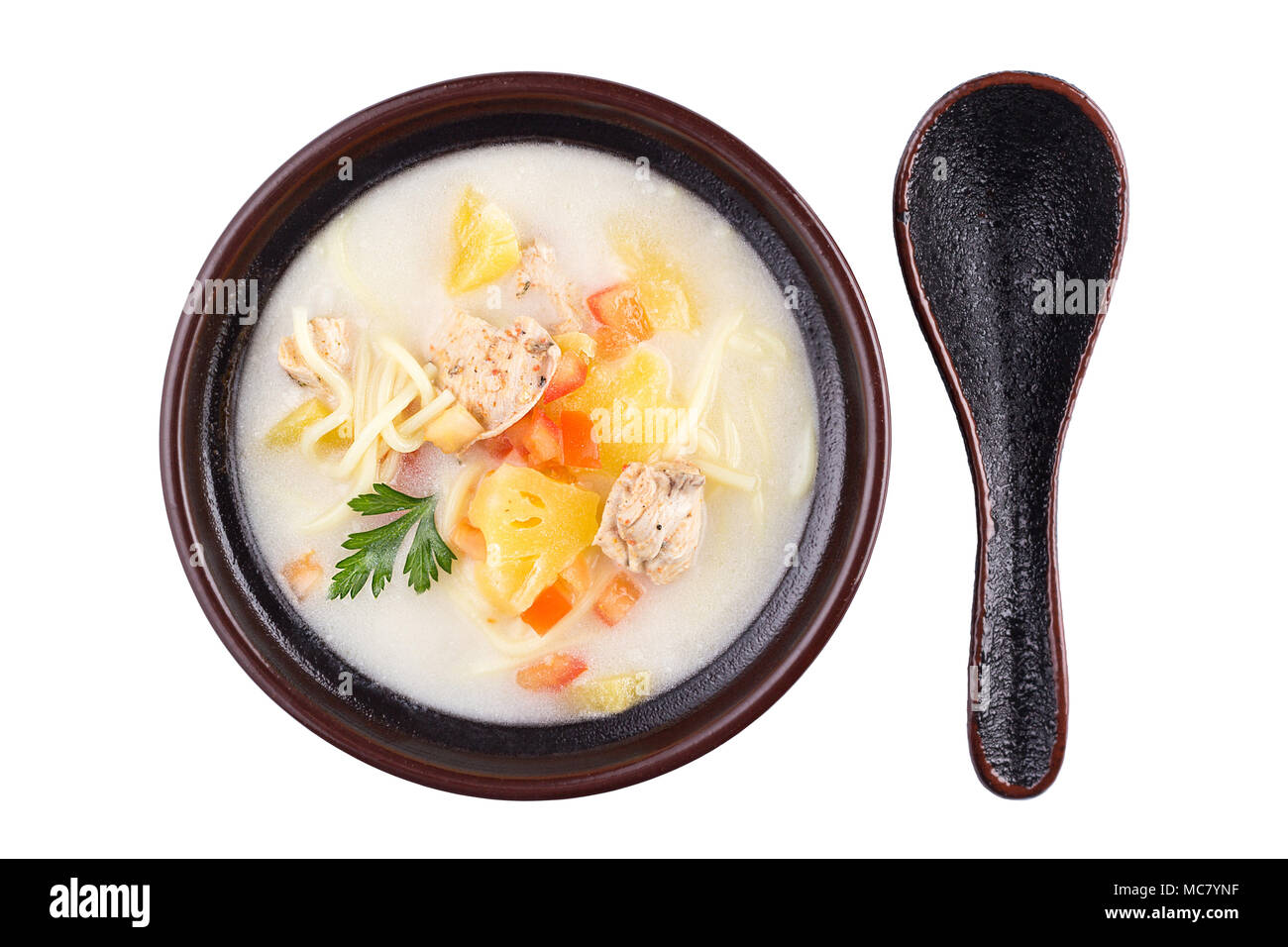 Delicious soup with meat and noodles. High angle view of Thai food - chicken and noodles in coconut milk soup isolated on white. Stock Photo