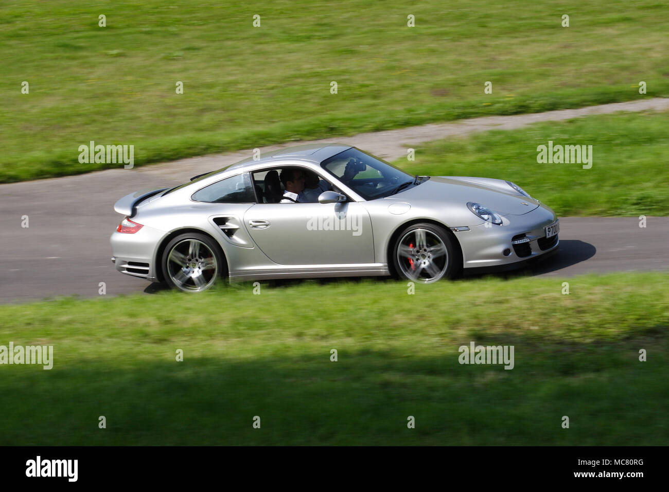 Silver Porsche 911 997 driving fast Stock Photo