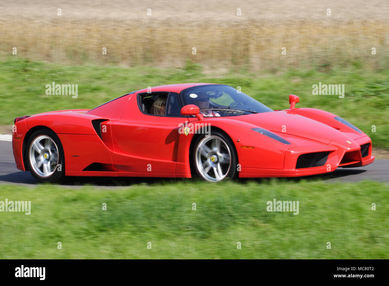 Beautiful Red Ferrari Enzo mid-engined V12 hyper car driving fast Stock Photo