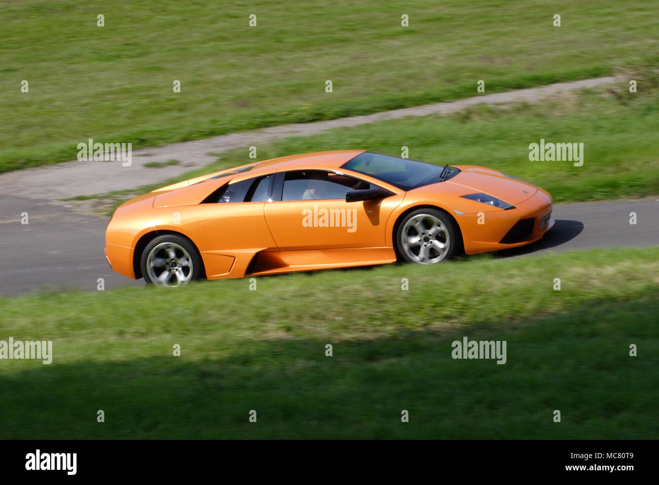 Orange Lamborghini Murcielago driving fast Stock Photo