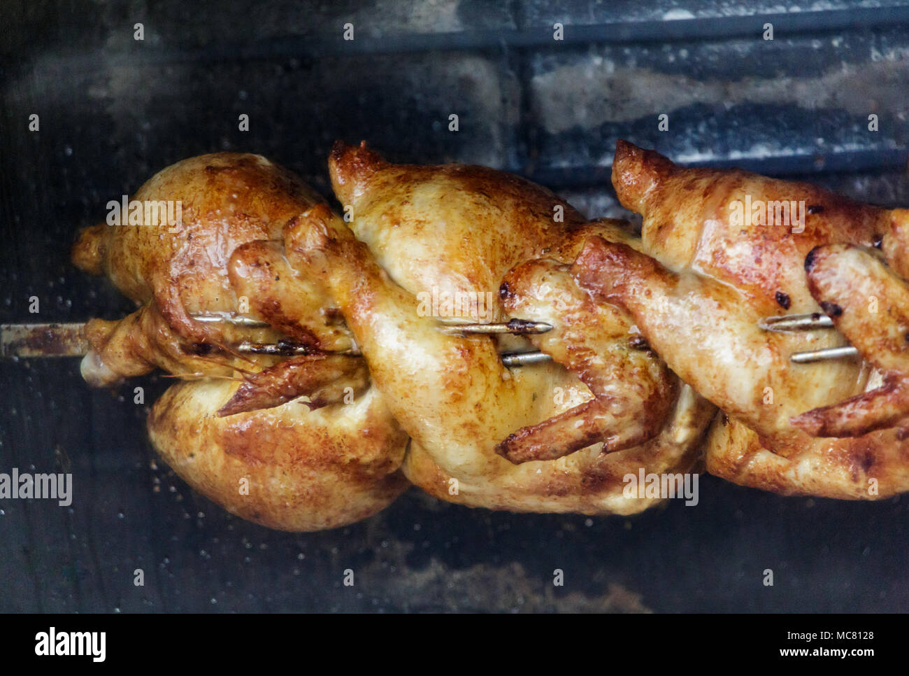 Three Chickens Roasting on a Rotisserie Spit Stock Photo Alamy