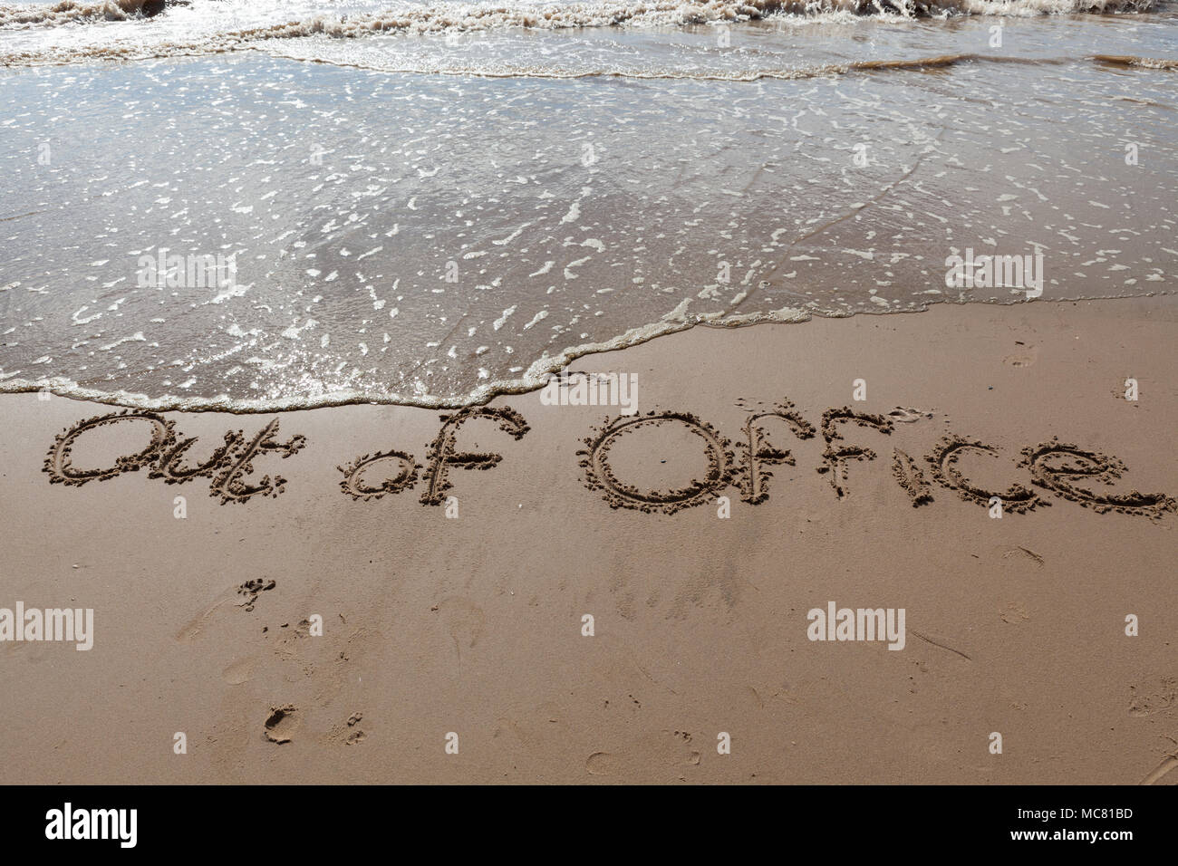 Out of Office written in the sand Stock Photo