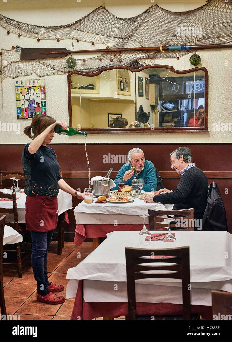 San Sebastian, Spain - March 28, 2018. Waitress serving Txakoli to customers. A tipycal wine with a slight carbonization produced in Basque Country. W Stock Photo