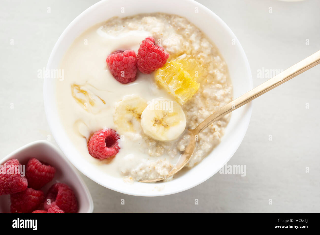 Porridge with banana yoghurt, banana, raspberries and honey Stock Photo