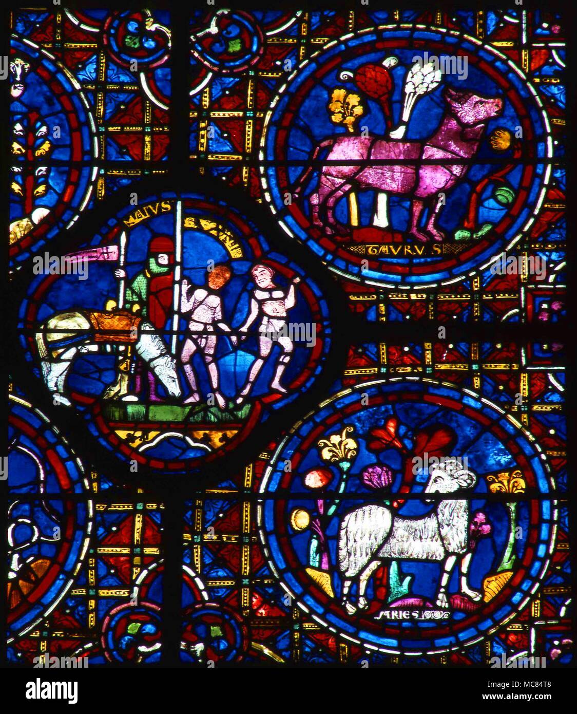 The zodiacal signs, Aries, Taurus and Gemini, alongside an image of the Month of May. Thirteenth century stained glass - detail from the zodiacal window in the south wall of Chartres cathedral. Stock Photo