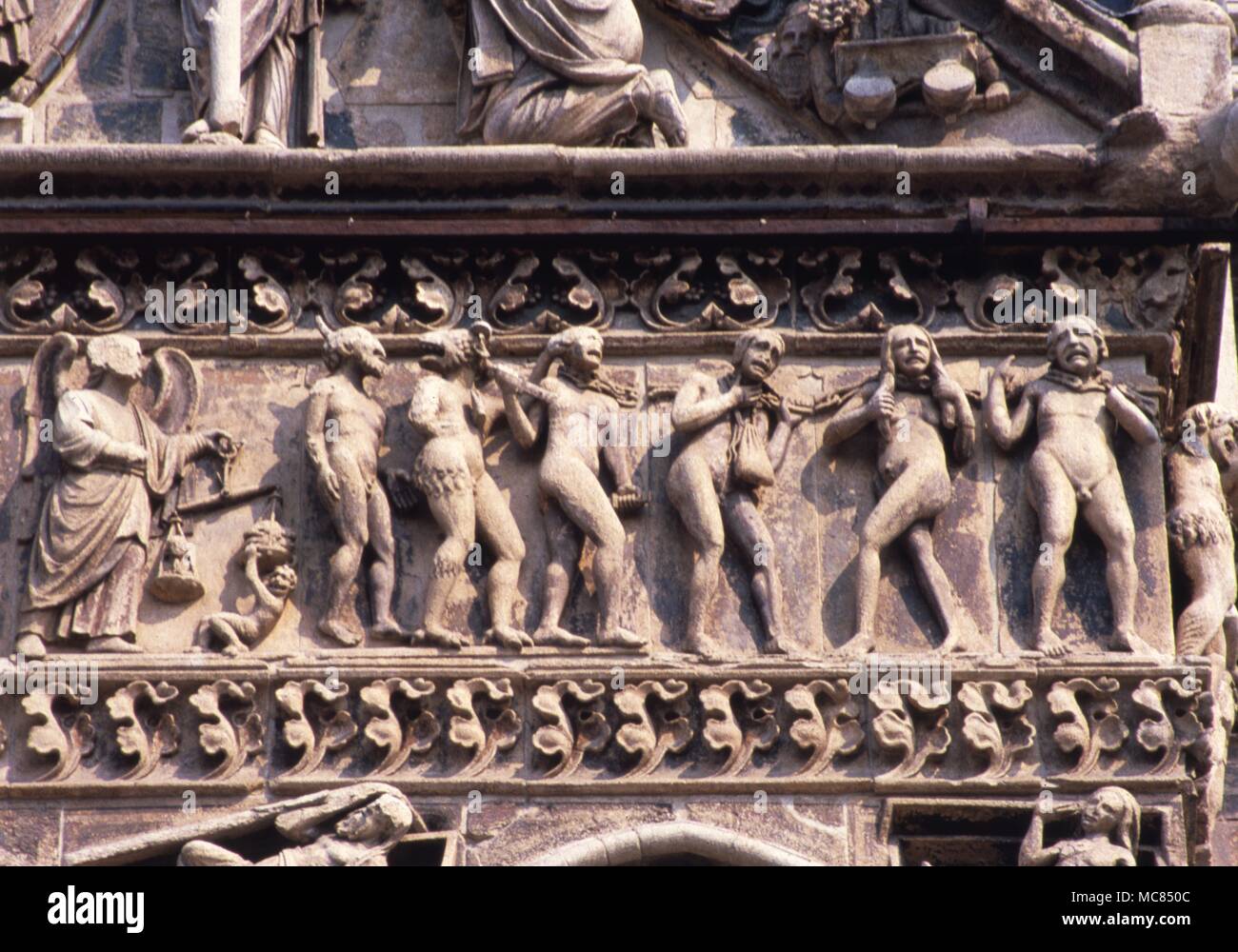 Procession of souls of the dead and psychopomp demons on the facace of the Cathedral at Ferrara, Italy. Thirteenth century. Stock Photo